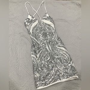 small white dress with silver sequence design, low V neck, cross over tie back.